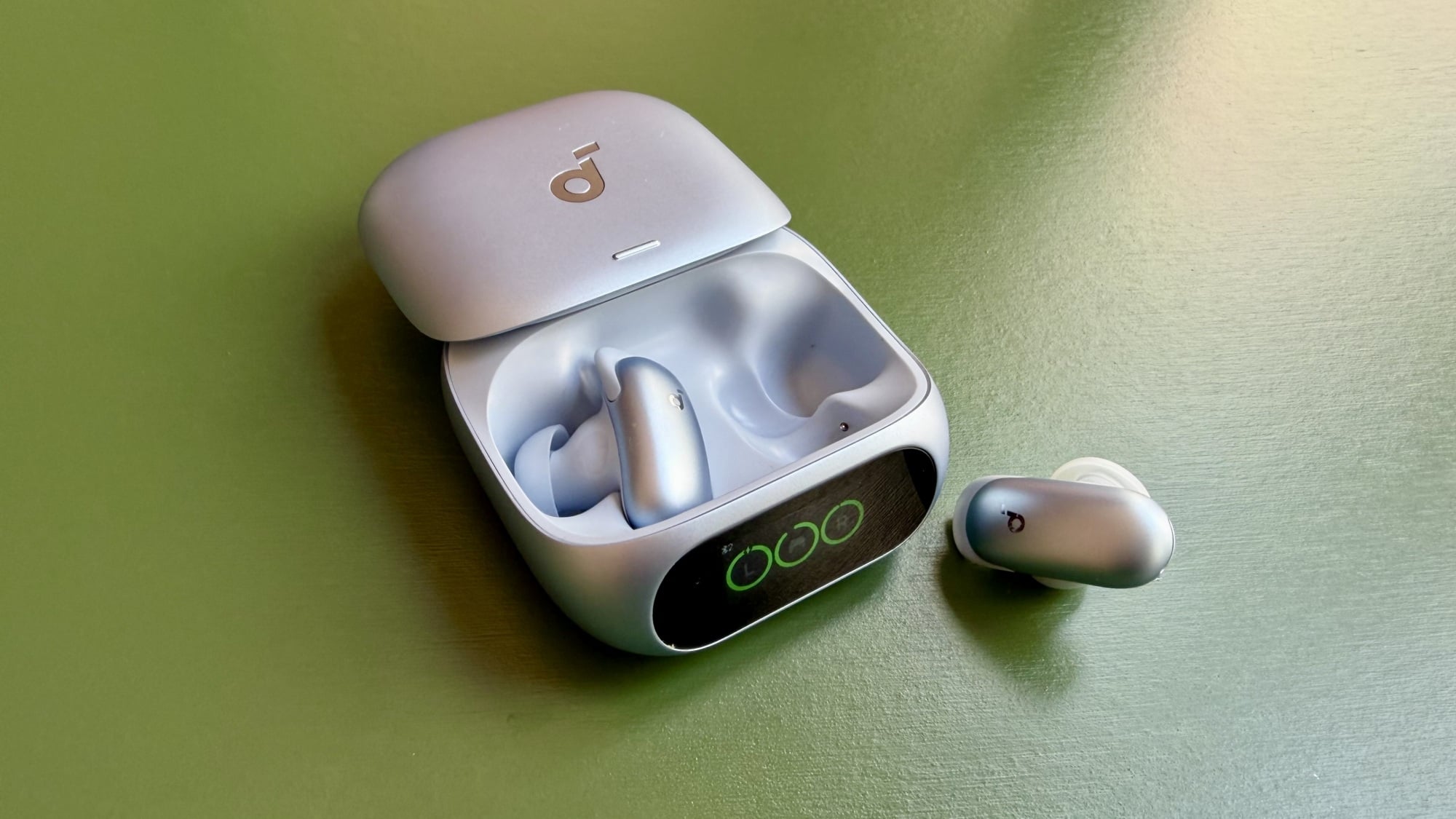 blue soundcore liberty 5 pro case and earbuds on green table