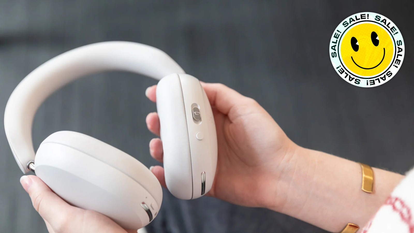 hands holding out Sonos Ace headphones in white 