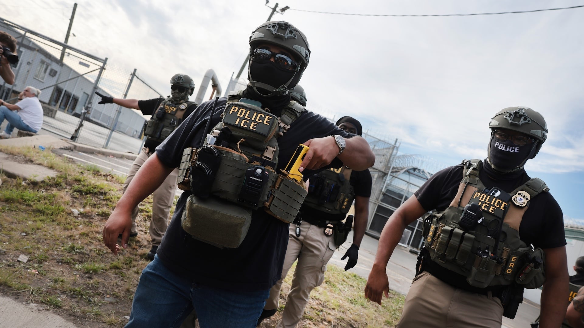 ICE agents stand guard in front of protesters outside the federal immigration center at Delaney Hall in Newark, where ICE is housing detained immigrants on May 26, 2026 in Newark, New Jersey.