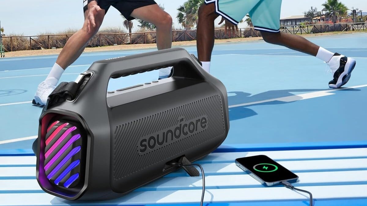 the  Soundcore Boom 2 speaker sits near a basketball court recharging a phone