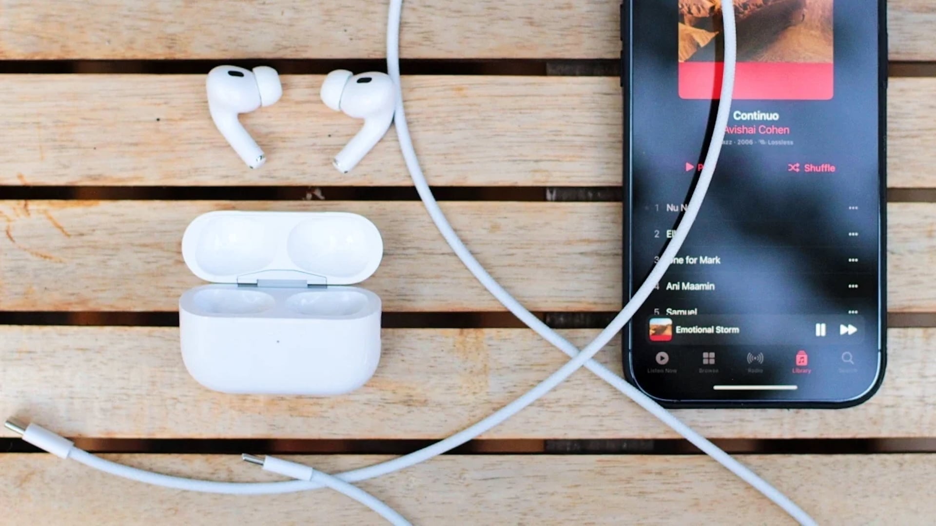 AirPods beside an iPhone on a table.