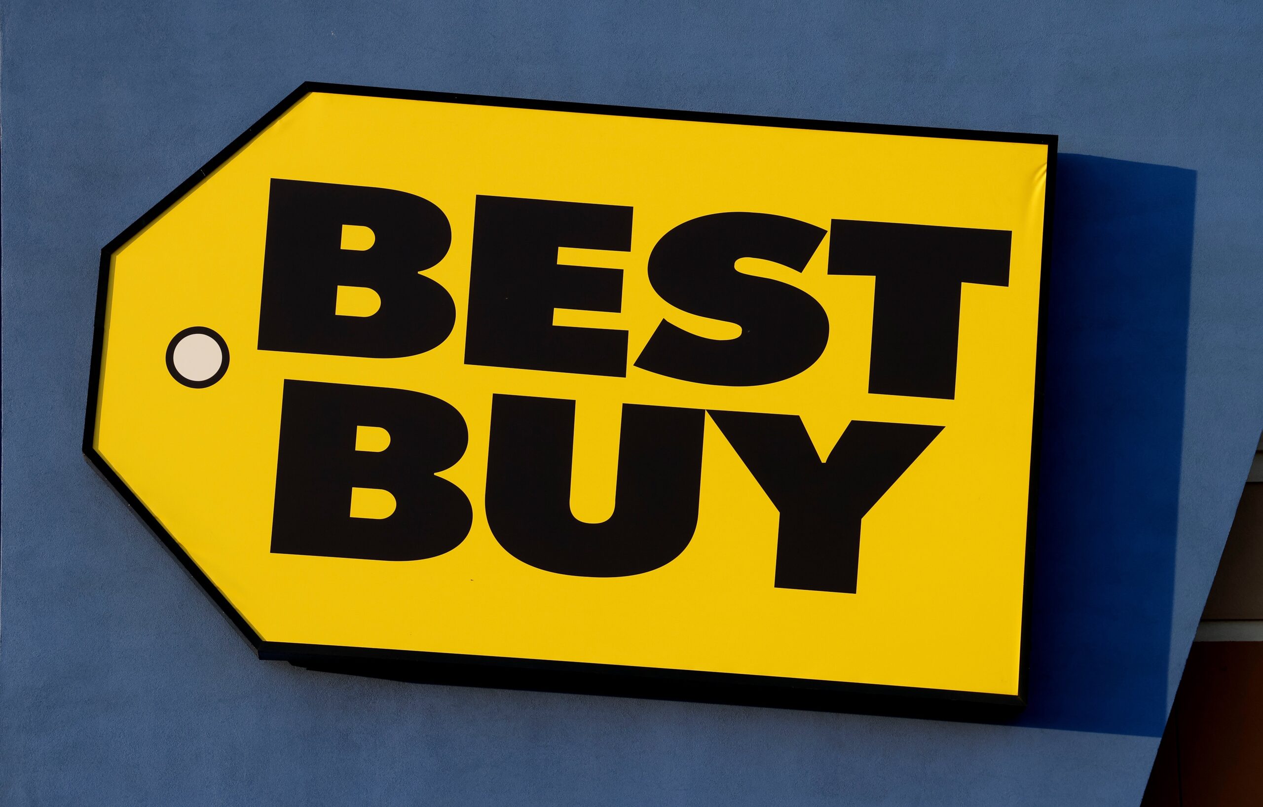 The rising sun illuminates a Best Buy corporate logo