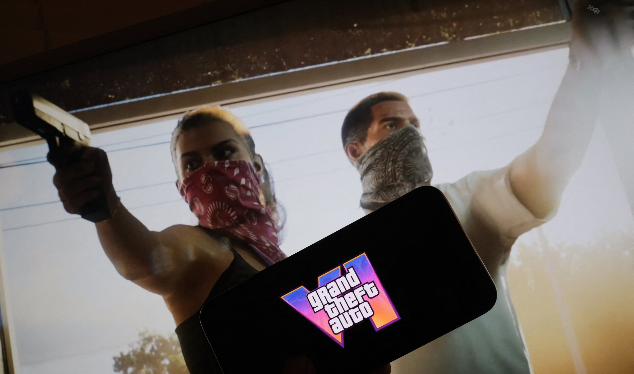 This illustration photo created in Los Angeles, December 4, 2023, shows Rockstar Games' Grand Theft Auto VI trailer played on a screen in front of the game title