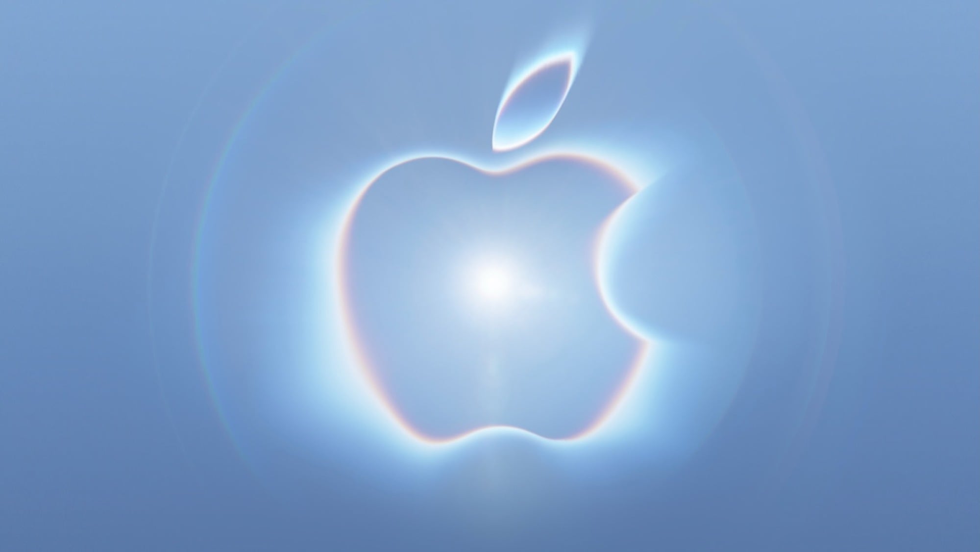 Apple logo with a glowing neon effect in blue and pink hues and a bright white flare at its center