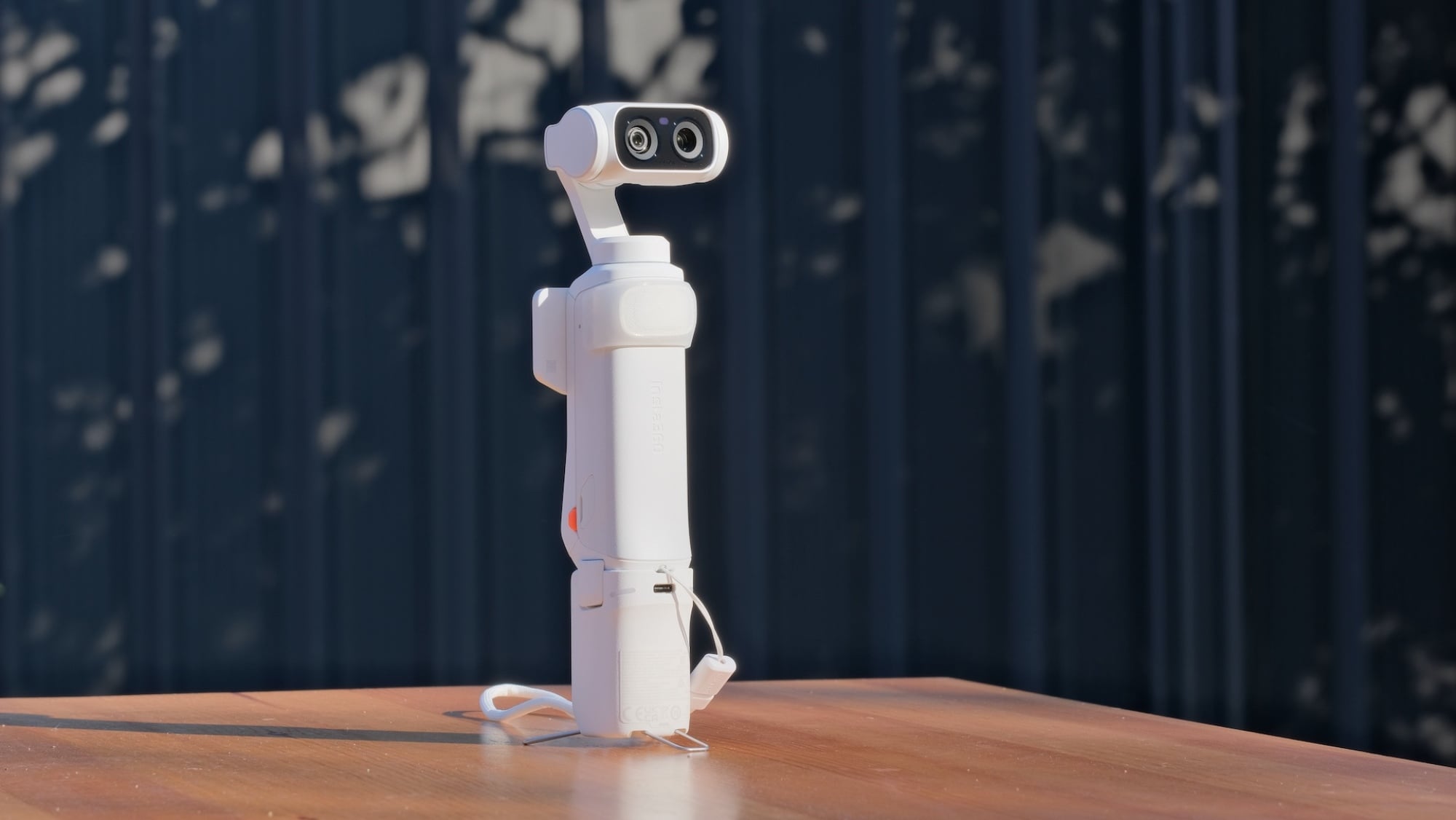 The Insta360 Luna Ultra with its battery handle attached and tripod feet deployed.