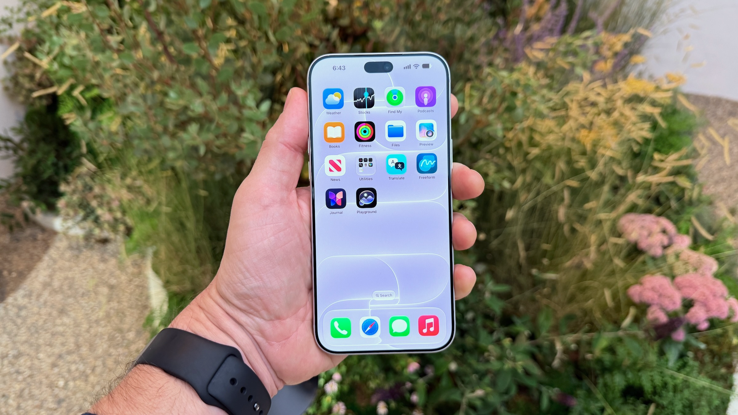 the iphone 18 pro held in hand with apps visible on screen