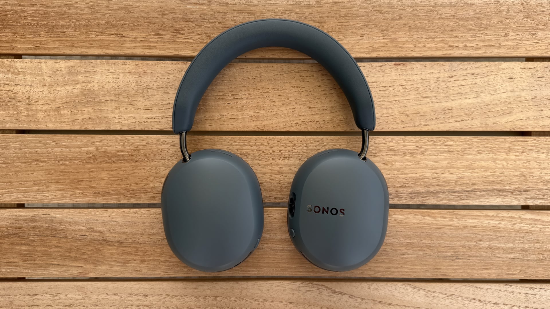 Sonos Ace Ultra headphones on wood panels