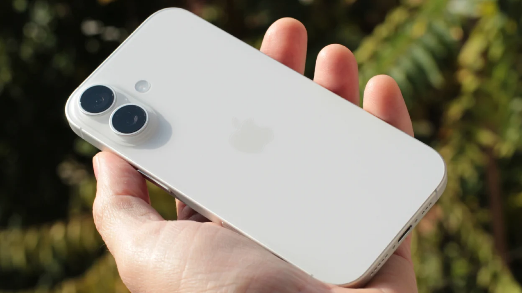 a man's hand holding the iphone 17