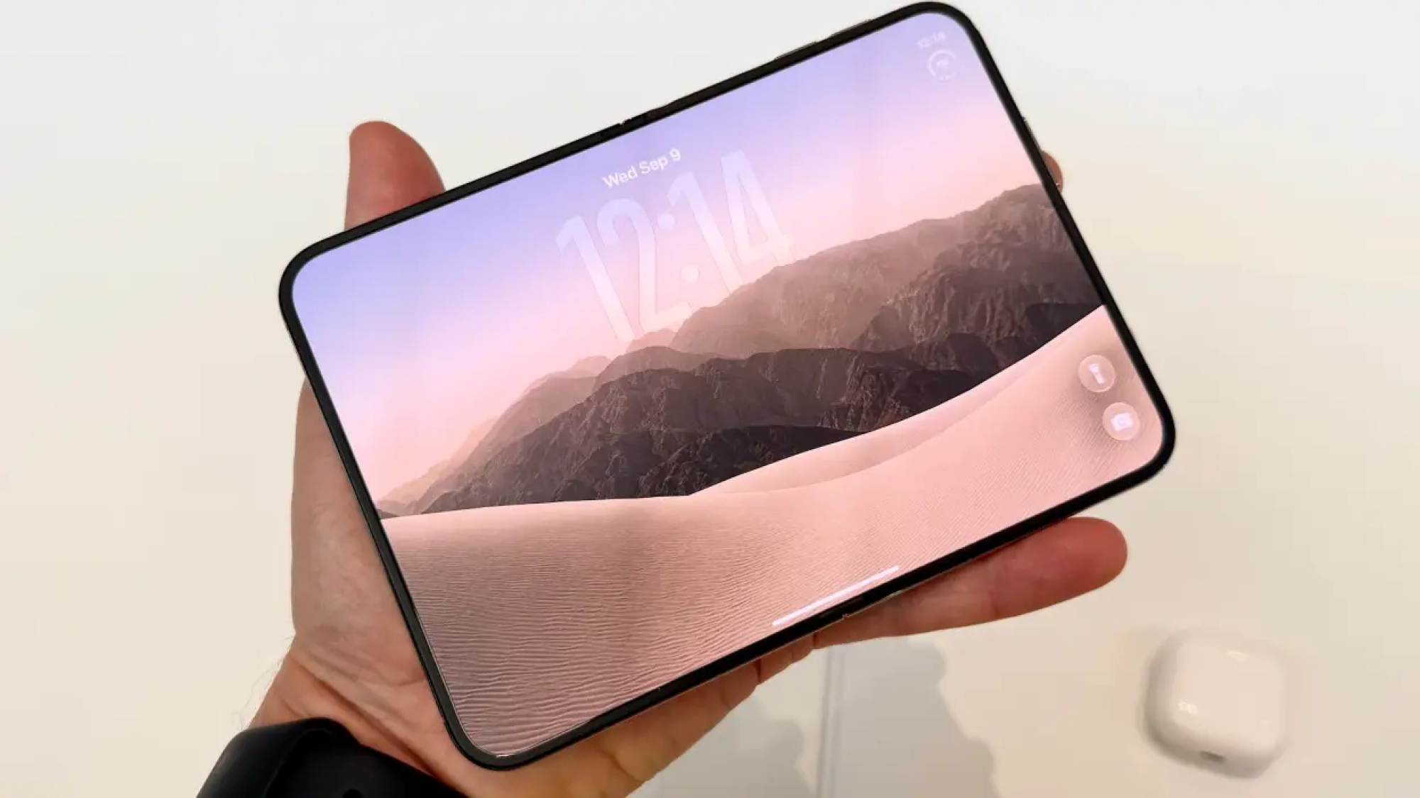 a man's hand holding an unfolded iphone duo