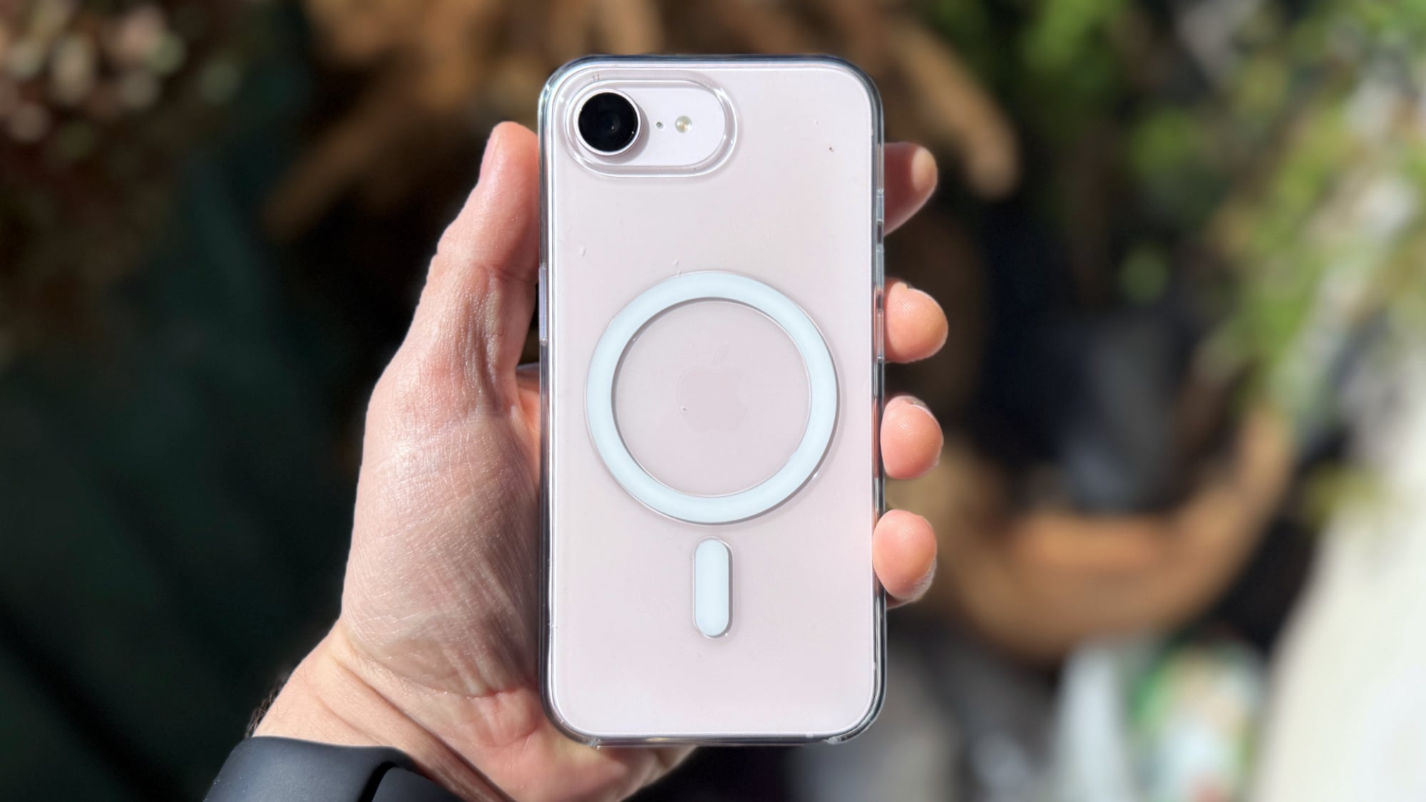 a man's hand holding the iphone 17e