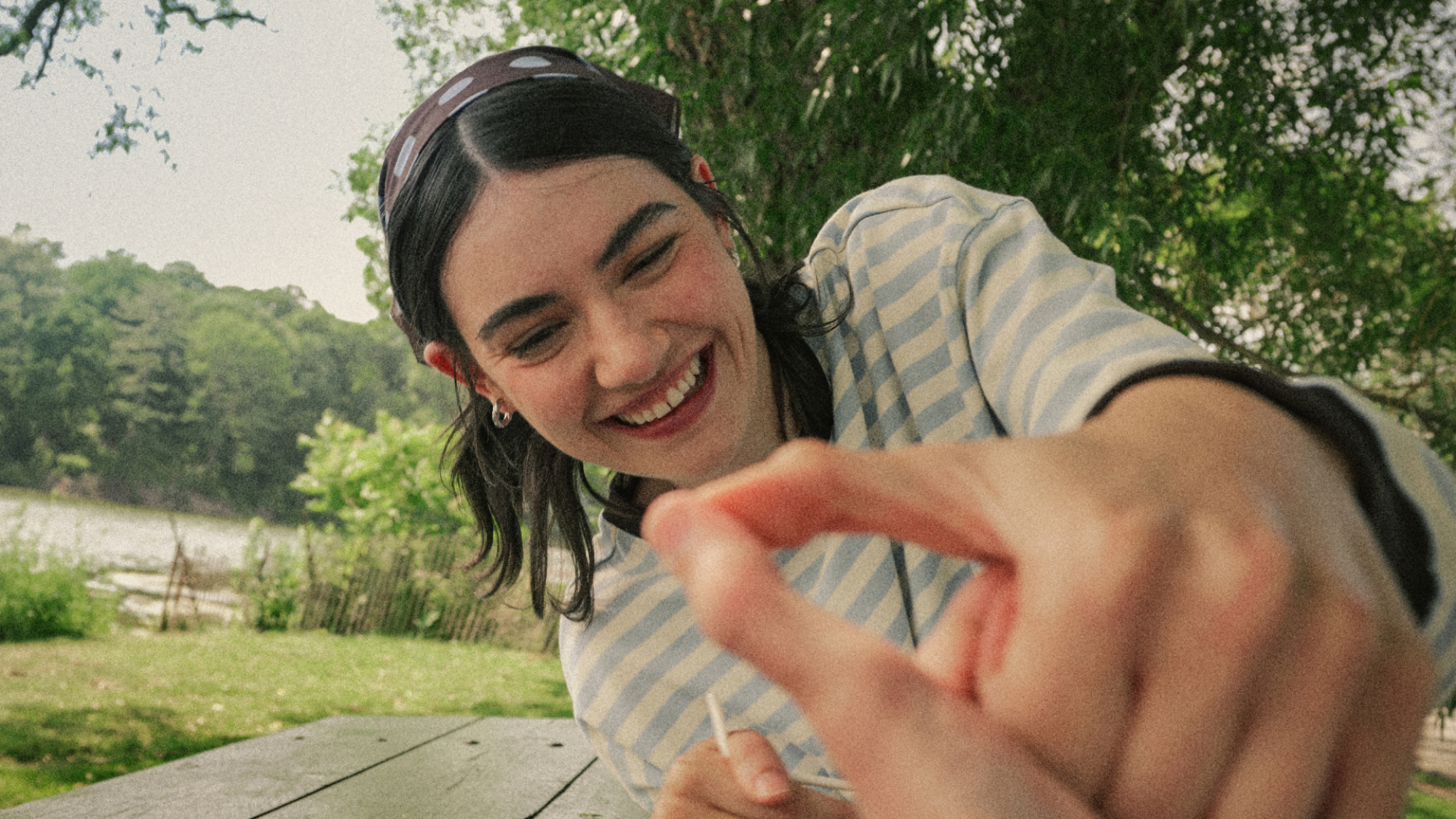 A woman playing thumb wars. The image has a grainy filmic effect.
