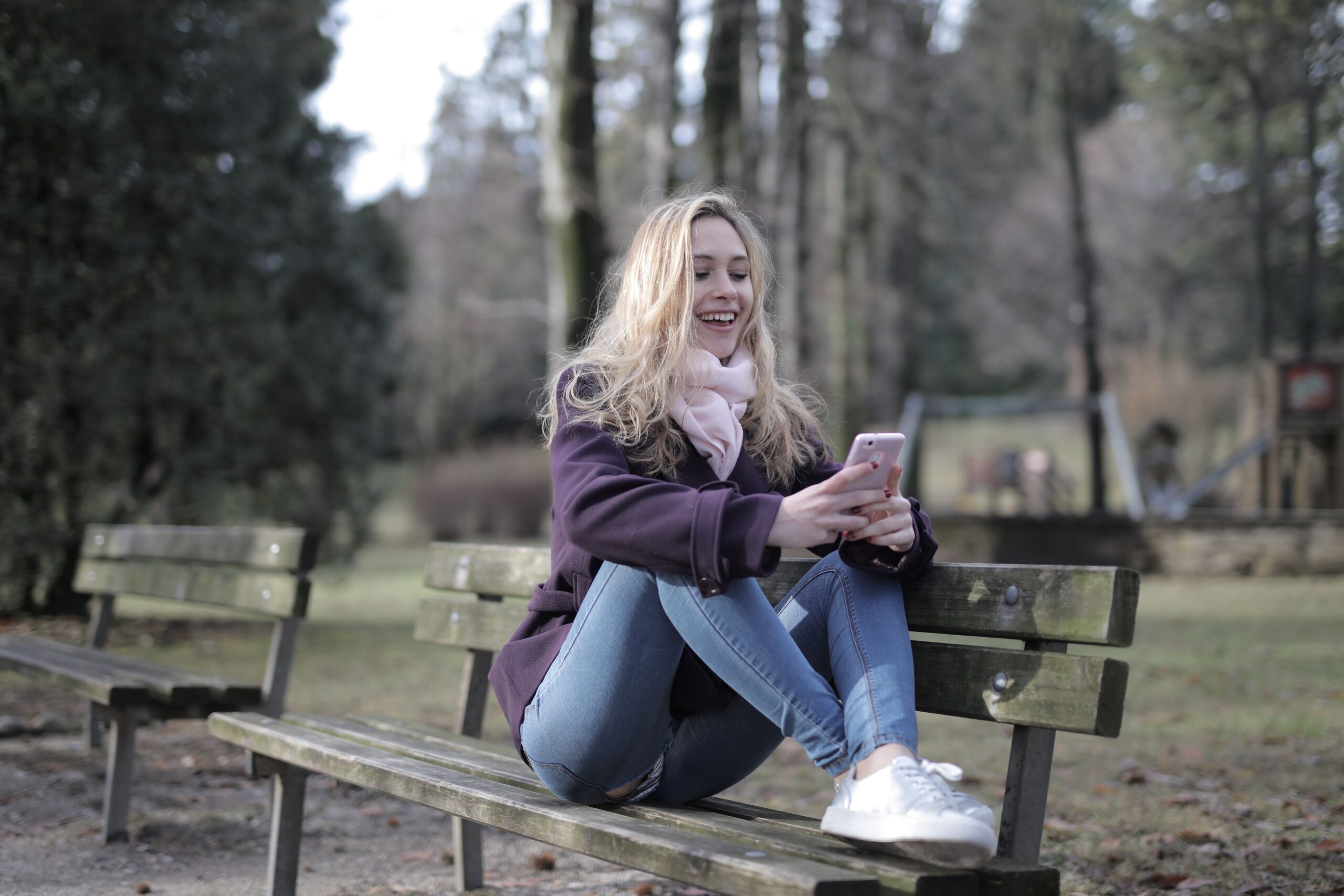 A woman using her phone and smiling