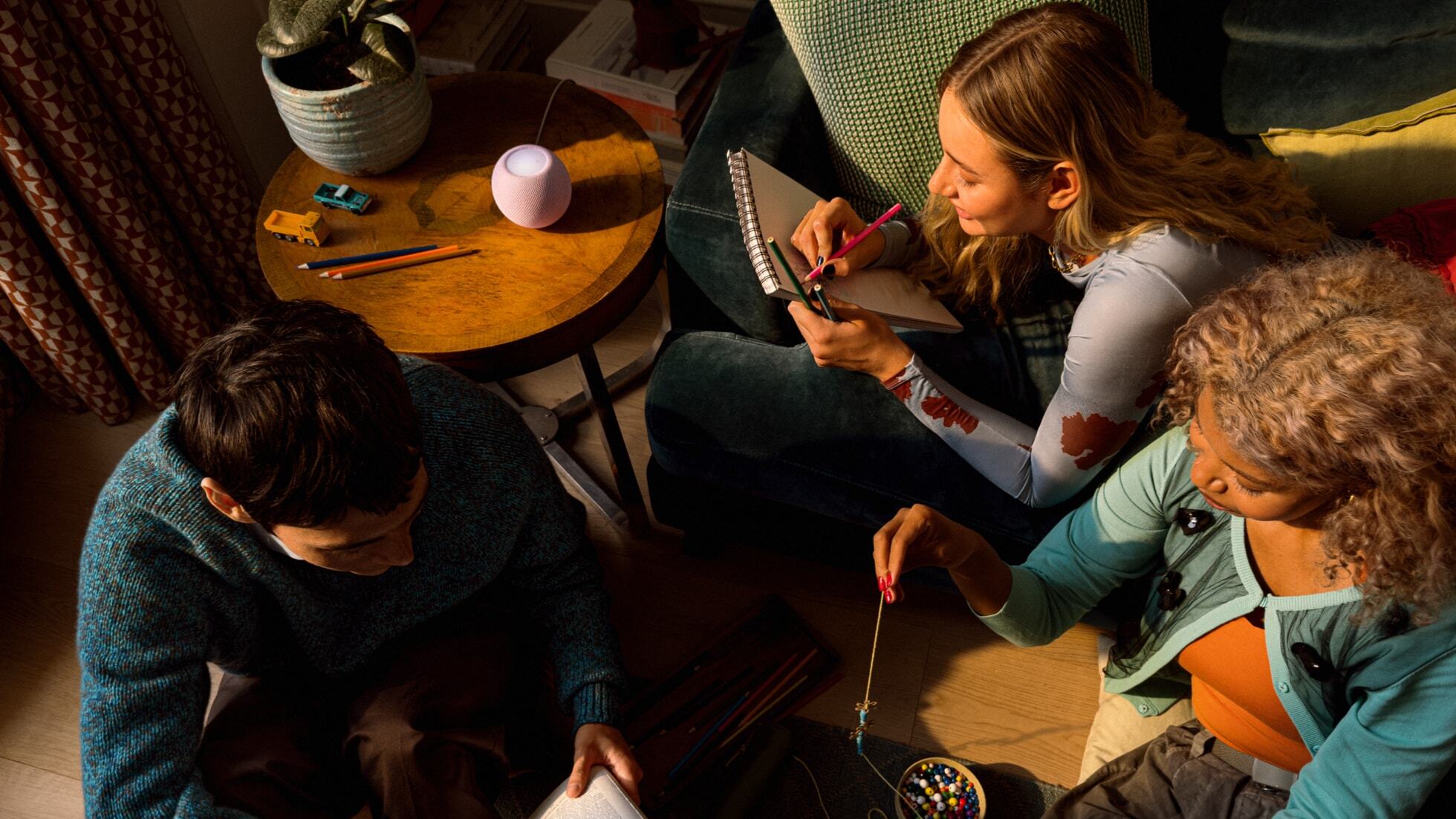 several people sit around a table that's holding an apple homepod mini 2