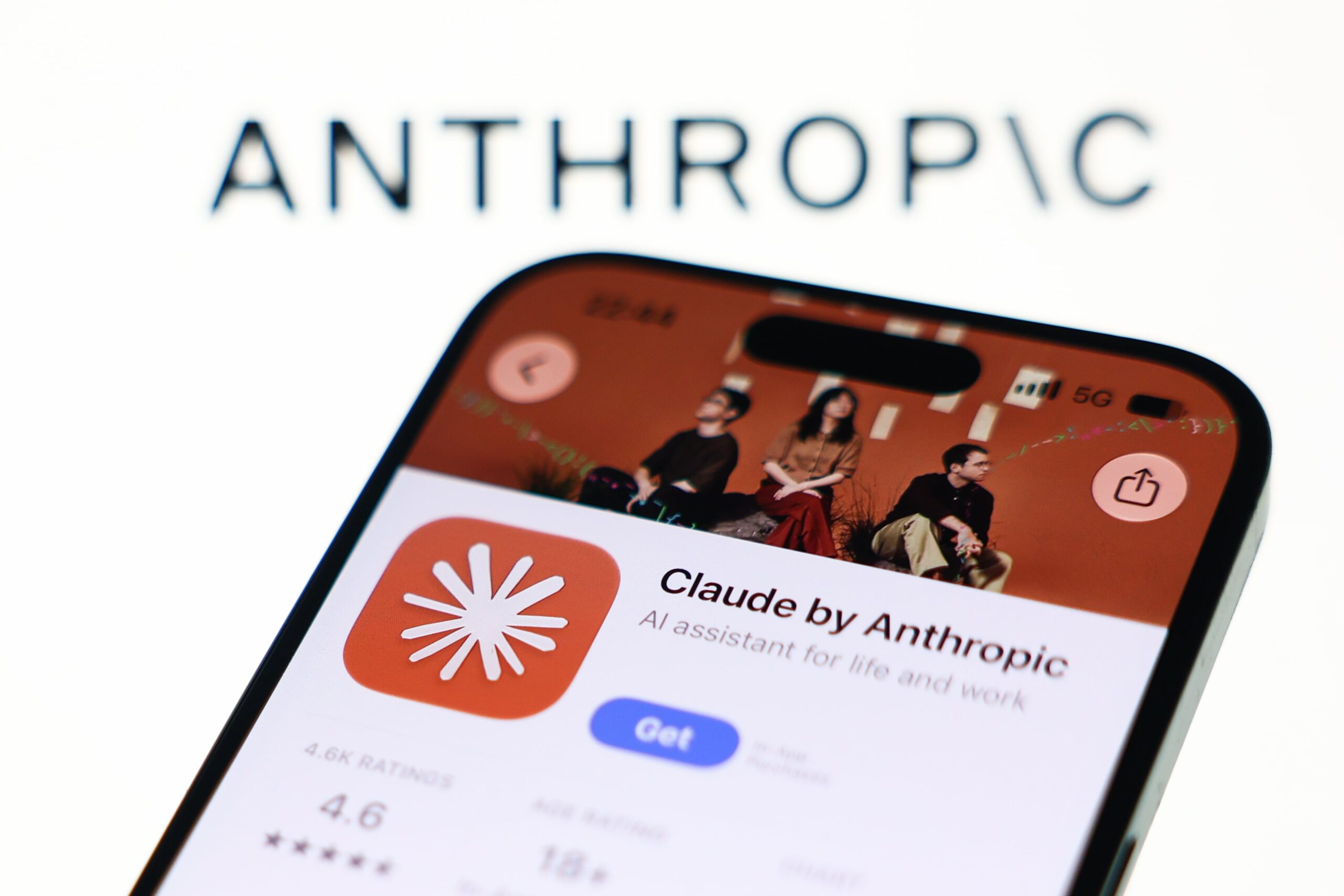 Anthropic logo displayed on a laptop screen and Claude on App Store displayed on a phone screen 