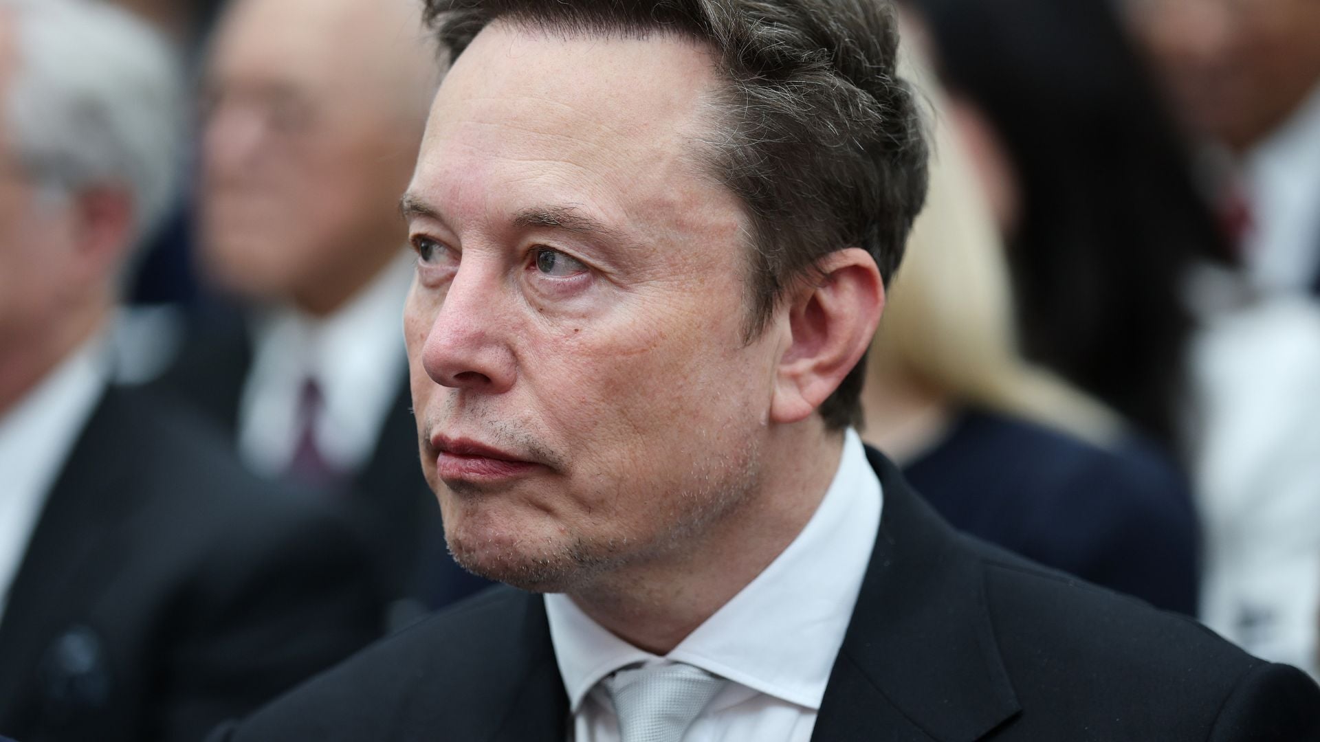 A close-up of a man in a suit at an event.