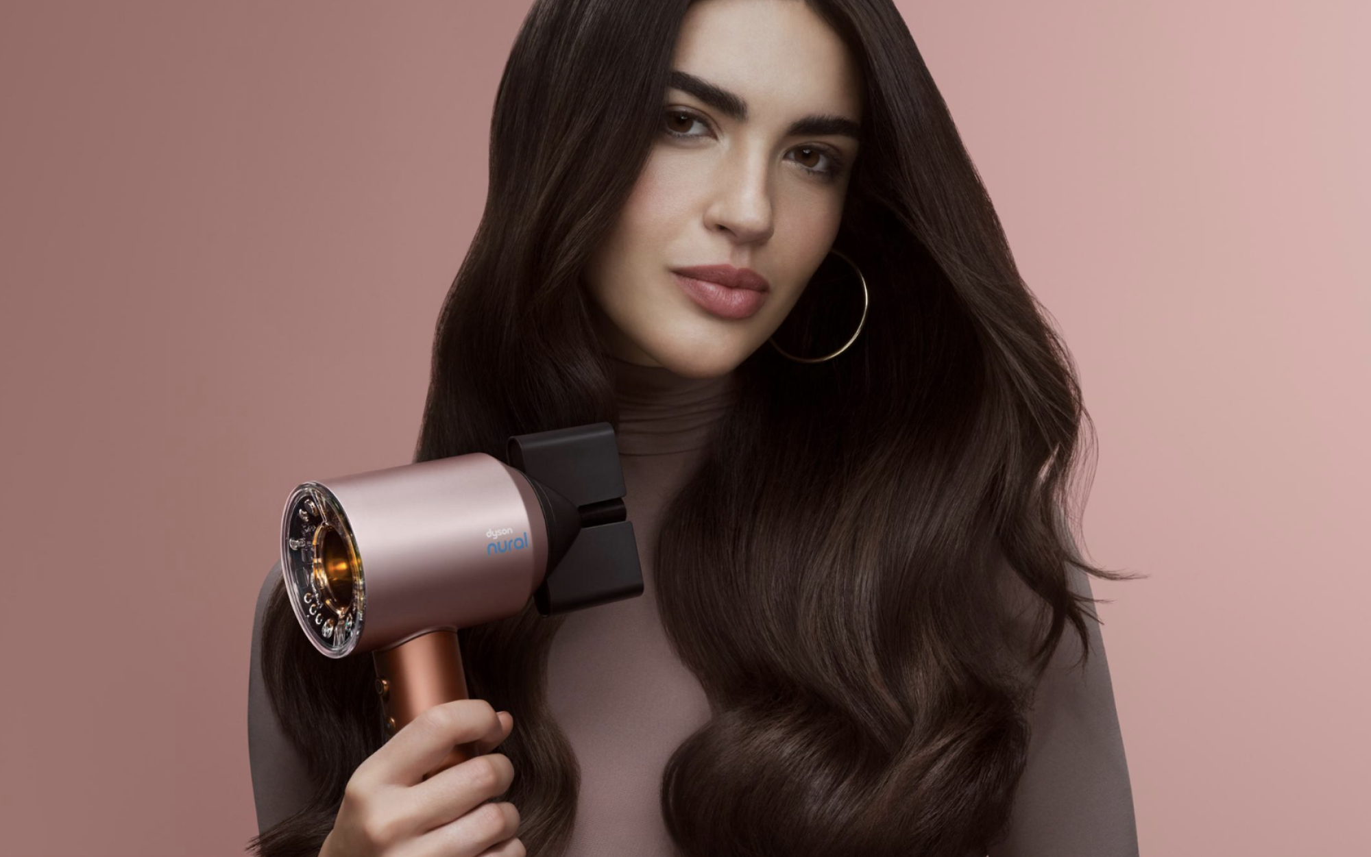 a woman holding a strawberry bronze dyson supersonic nural